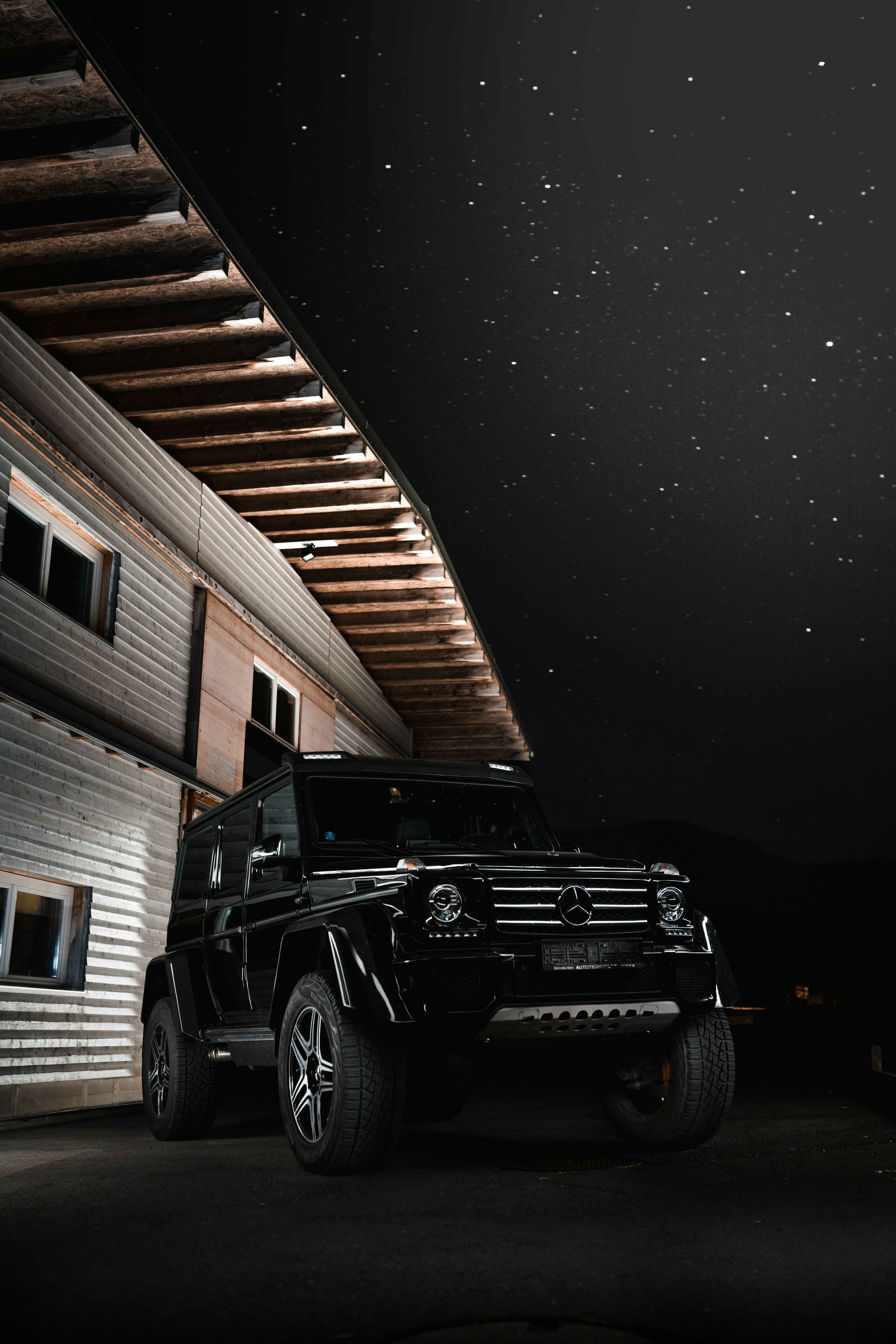 black jeep wrangler parked near brown wooden wall